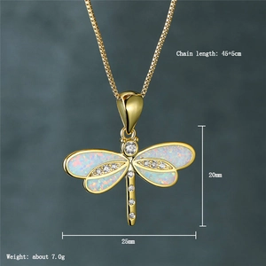 Macro view of dragonfly pendant with white synthetic opal and sparkling diamonds