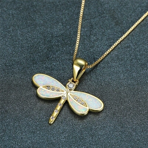 Elegant gold dragonfly pendant necklace with white opal wings and sparkling accents