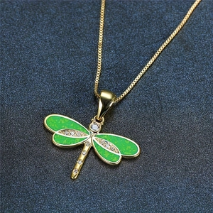 Macro view of golden dragonfly pendant necklace with green opal stones and small diamonds