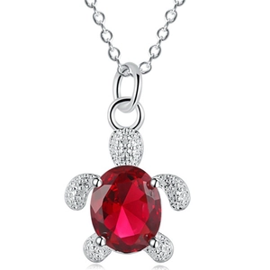 Sparkling silver sea turtle pendant necklace with a vibrant red oval faceted gemstone
