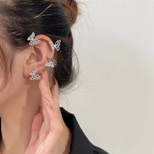 Detailed view of silver butterfly ear cuff with sparkling zircon stones on a model