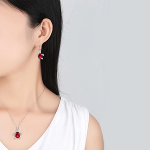 Detail of crystal turtle pendant necklace and matching earrings set on a female model