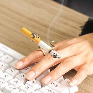 Detailansicht eines kreativen Schlangen-Raucherrings mit Zigarette über einer Tastatur