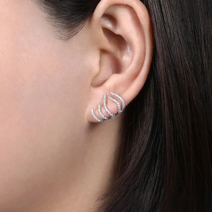 Pendientes de garra plateados con circonitas lucidos por una modelo en vista lateral