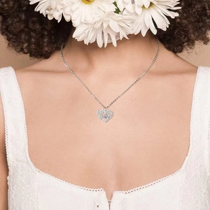 Silberne Herzenskette mit Schmetterling und blauem Zirkonia am Hals getragen
