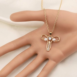 Détail du pendentif utérus avec cristal coeur et perles sur chaîne dorée