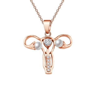 Collier utérus en or rose avec zircon en forme de cœur et perles sur fond blanc