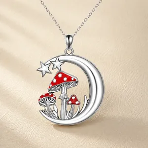 Detail of silver moon necklace featuring a red enamel mushroom and star pendant