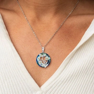 Collana con pendente a margherita in cristallo indossata da una modella su maglia bianca