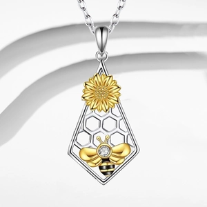 Detalle del collar bicolor con colgante de abeja, girasol y diseño de panal hueco