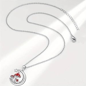 Silver crescent moon necklace with red mushroom charms on a white background