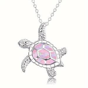 Macro shot of a sea turtle pendant with vibrant pink opal inlay and silver chain