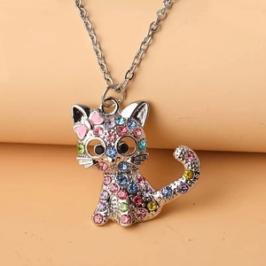 Macro shot of silver cat necklace pendant encrusted with colorful rhinestones and pink bow