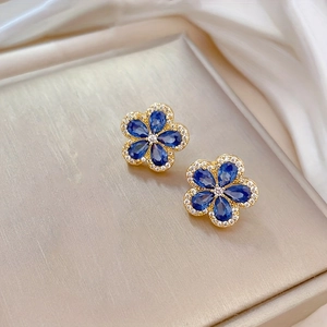Parure bijoux fleur de cerisier avec boucles d'oreilles saphir bleu sur fond soie