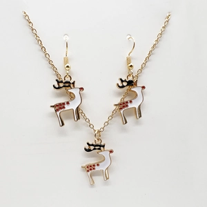 Detail of Christmas reindeer necklace and earrings set in gold with festive red and white enamel