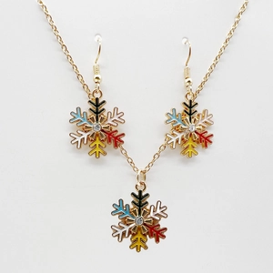 Macro view of gold snowflake necklace and earrings set with colorful enamel and crystals