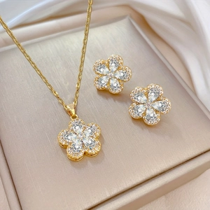 Vue détaillée d'un ensemble collier et boucles d'oreilles fleur dorée avec cristaux