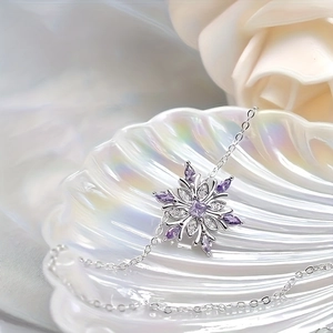 Elegant silver snowflake necklace featuring purple gemstones and zircons on shell background