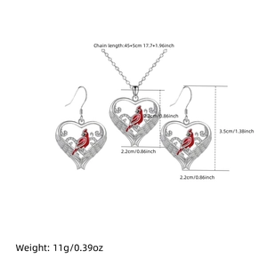Detailed view of red cardinal heart pendant necklace and earrings with silver finish