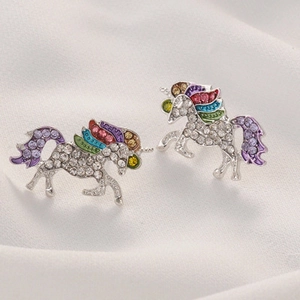 Close-up of unicorn stud earrings with silver finish, white rhinestones and colorful enamel