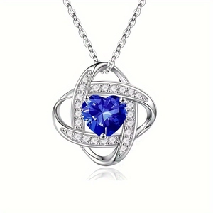 Macro detail of heart necklace featuring deep blue heart stone and pavé crystal setting