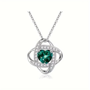 Close-up of green heart gemstone necklace with twisted silver knot and crystals