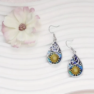 Fashionable sunflower teardrop earrings in silver and gold finish on a white surface