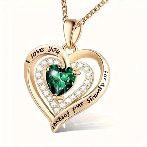 Detailed macro view of heart pendant with green gemstone and I Love You engraving