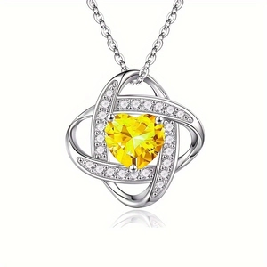 Detail of silver heart pendant with yellow gemstone and sparkling white crystals