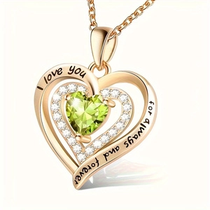 Detail of rose gold heart pendant with green gem and 'I love you' engraving on the rim