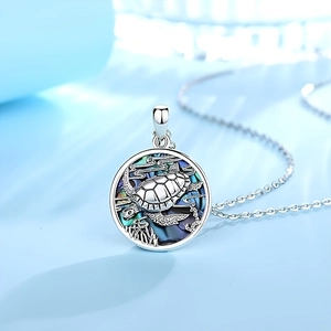 Detailed view of turtle pendant featuring colorful abalone shell inlay on silver chain
