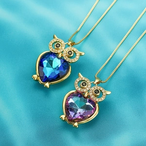 Schattige uil hanger ketting met hartvormig kristal in blauw en roze op blauw satijn