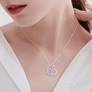 Cute cartoon cat and heart pendant necklace in silver worn by a female model