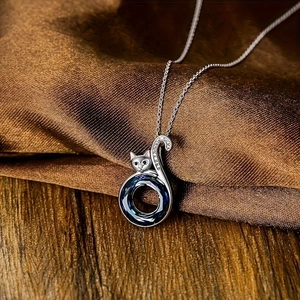 Kattenhanger ketting met donkerblauwe kristal en zirkoon op zijden achtergrond