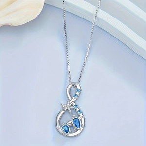 Sea turtle and starfish ocean necklace with blue gems on a shell and wave display