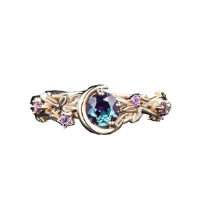 Detail of vintage gold crescent moon ring with purple zircon and vine engraving