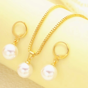 Elegantes Goldperlen-Schmuckset mit einer Anhängerkette und passenden Ohrhängern