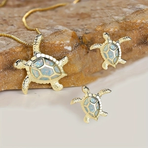 Süßes Schildkröten-Schmuckset mit goldener Kette und Opal-Ohrsteckern auf Naturstein