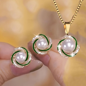 Elegante gouden sieradenset met witte parels en groene emaille spiraal accenten
