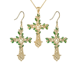 Close-up of golden Celtic cross necklace and earrings set with green enamel leaves