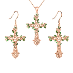 Detailed view of rose gold Celtic cross jewelry set with green enamel vine leaves