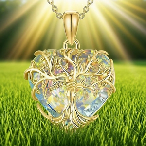 Collier cœur doré avec pendentif cristal arbre de vie sur une pelouse verte ensoleillée