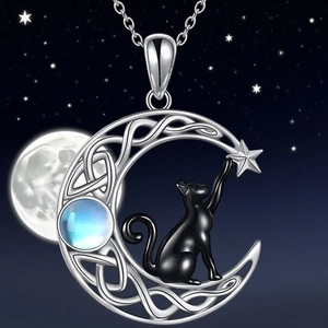 Detail of star and moon cat pendant featuring blue moonstone and black cat motif