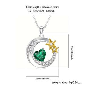 Detalle del colgante de luna plateada con corazón esmeralda y acentos de estrellas doradas