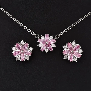 Close-up of pink flower jewelry set including necklace and earrings on black leather