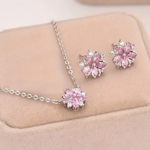 Detailed shot of cherry blossom jewelry set with pink stones in a beige velvet gift box
