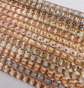 Flat lay of diverse 18K gold-plated stainless steel Italian charms with colorful enamel patterns