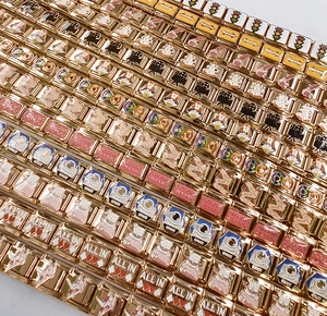 Detalle de dijes italianos modulares dorados con diseños coloridos de esmalte estilo pop