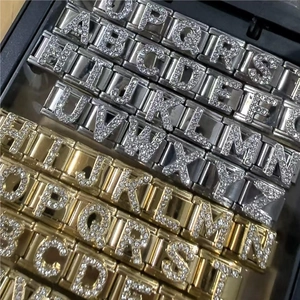 Detailed macro view of gold and silver Italian charm links with zircon alphabet letters