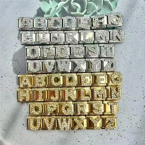 Flat lay of gold and silver stainless steel DIY letter charm links with zircon crystals